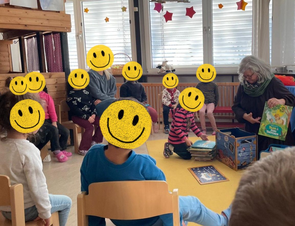 Kindergartenkinder sitzen im Kreis und suchen Bücher aus.